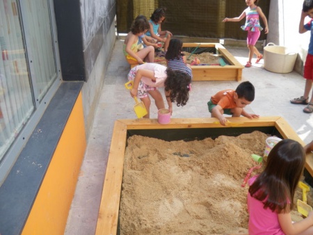 Niños jugando en el arenero de la ludoteca