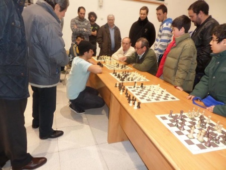 Emil, en cuclillas, durante una de las veinte partidas simultáneas