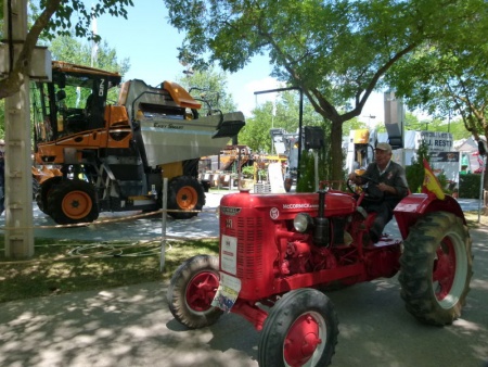 Un tractor de 1950 pasa entre moderna maquinaria