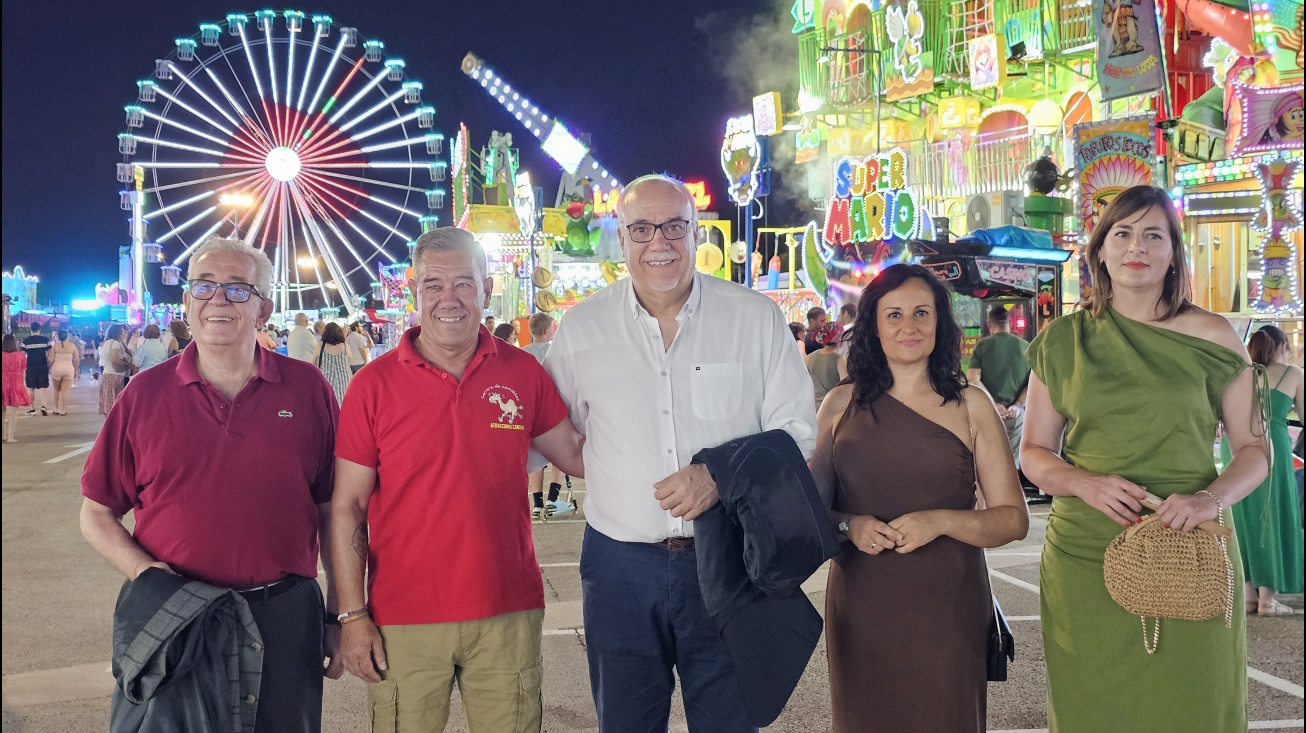 Autoridades junto al representante de la asociación de feriantes con la noria al fondo